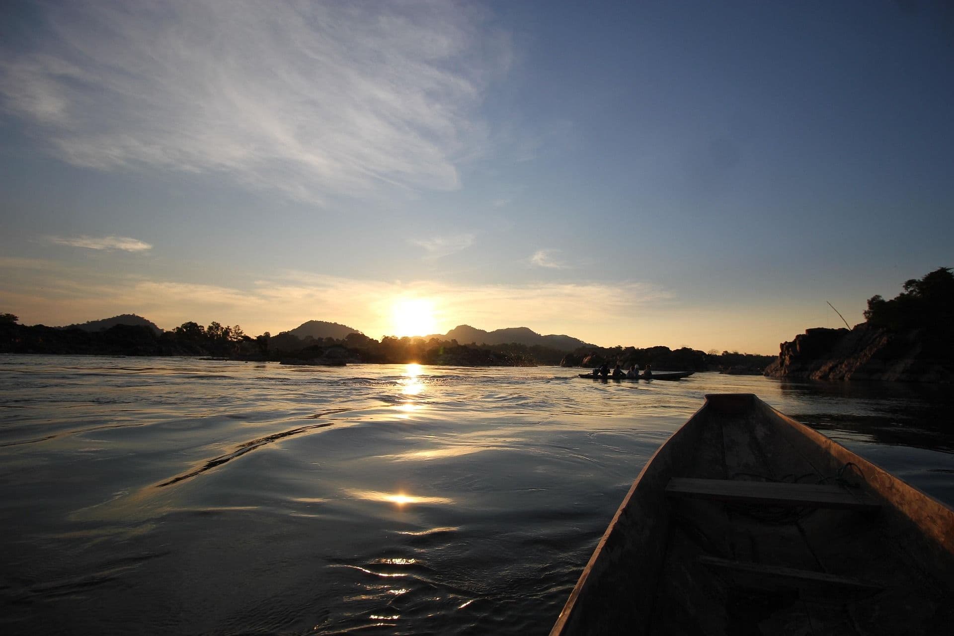 A kayak on the water during sunrise, everything is still dark