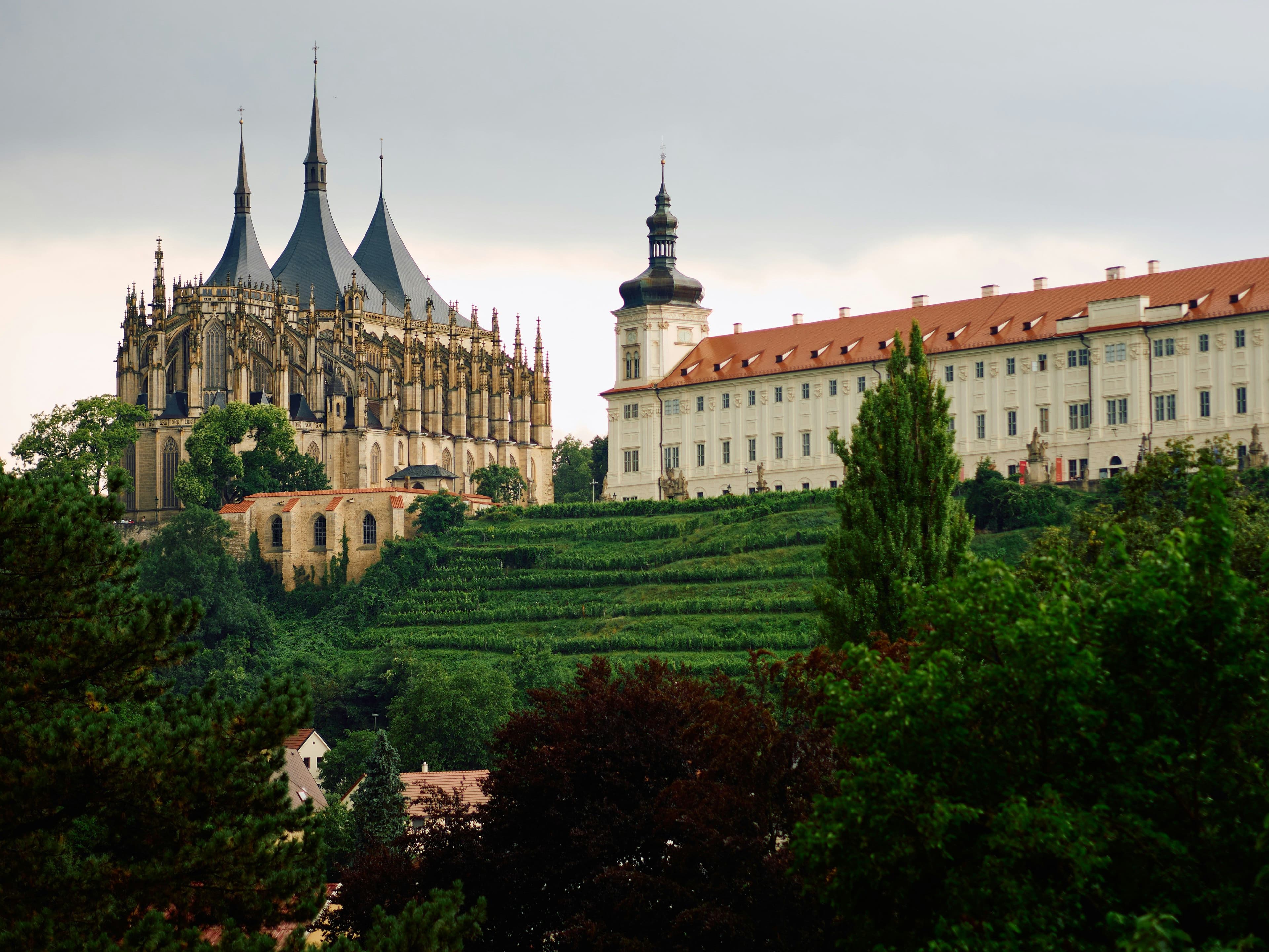 Kutná Hora castle situated on a green hill, and the parliaments building on the right on top of the hill