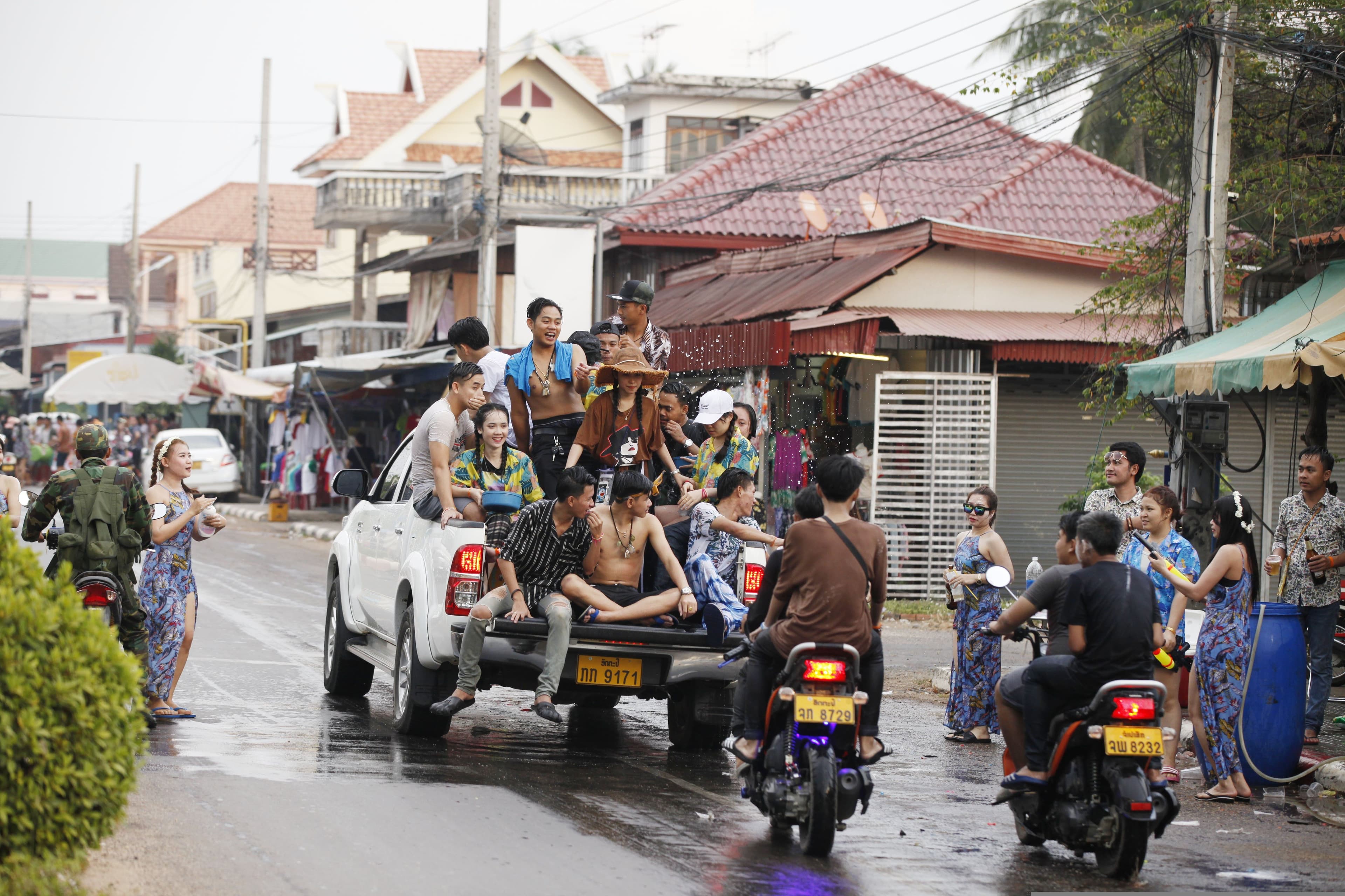 Laos waterfight new year people sitting on a truck throwing water