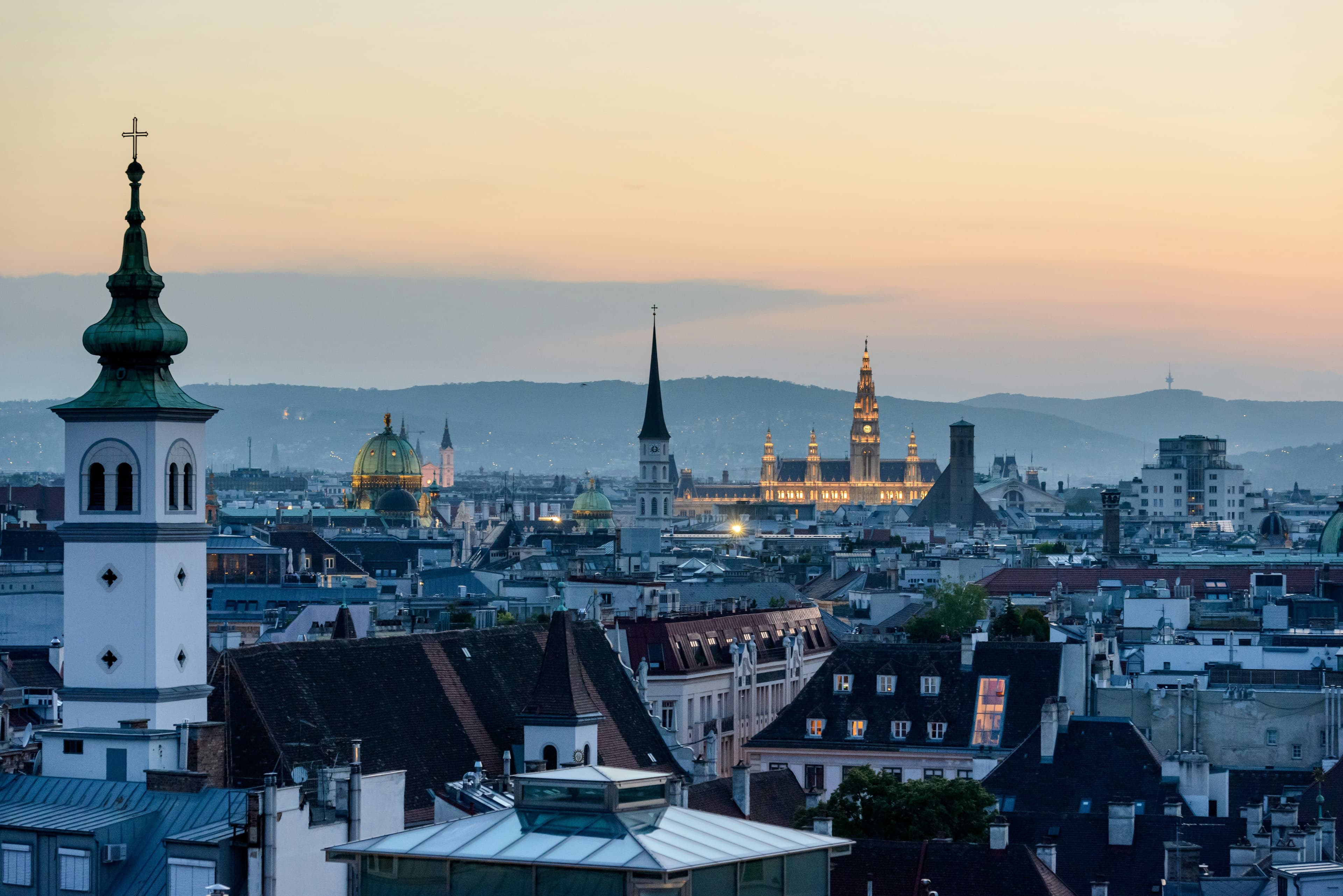 The city of vienna from above with a church tower on the left.