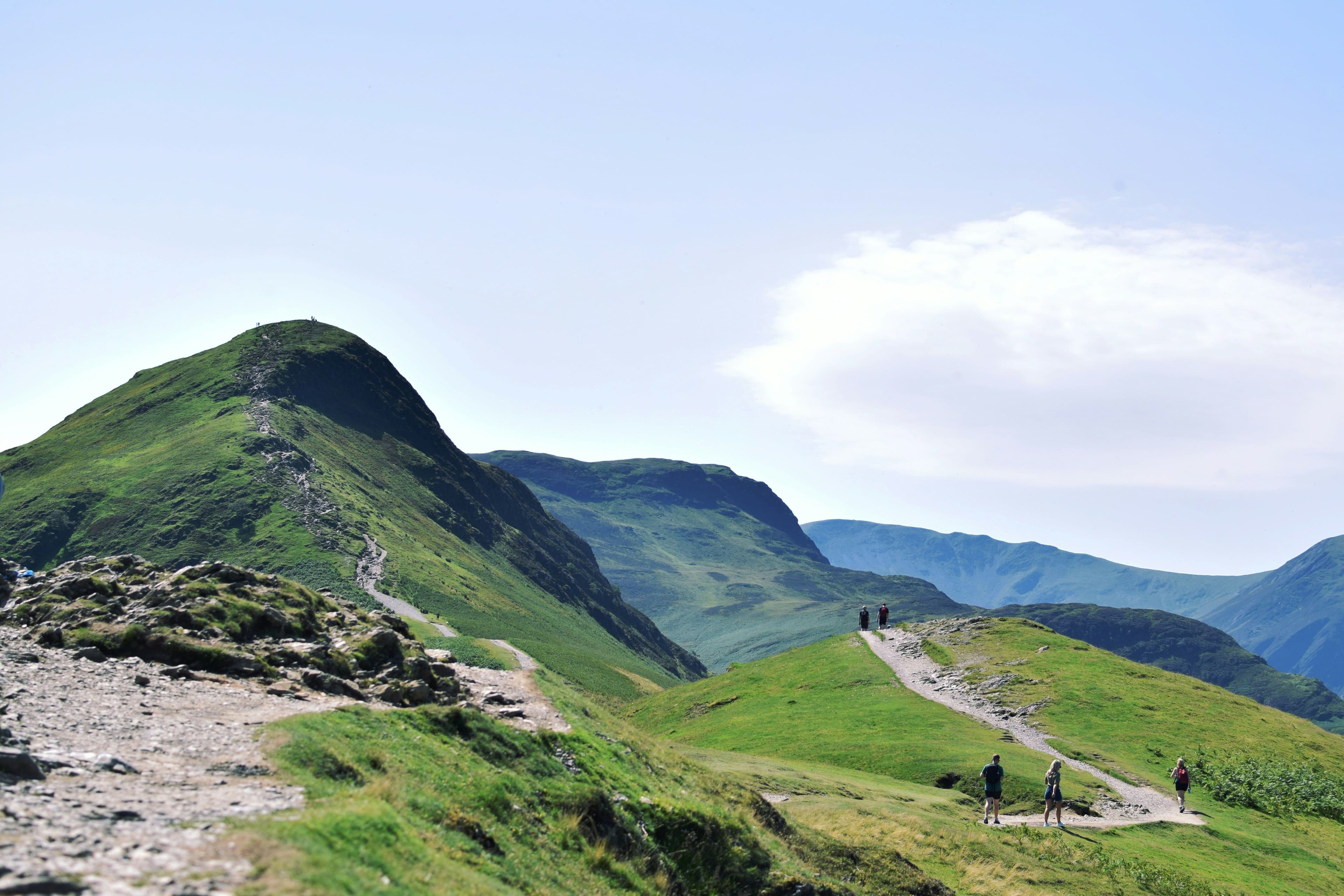 A windy path on green lush mountains and hills in England on a clear day