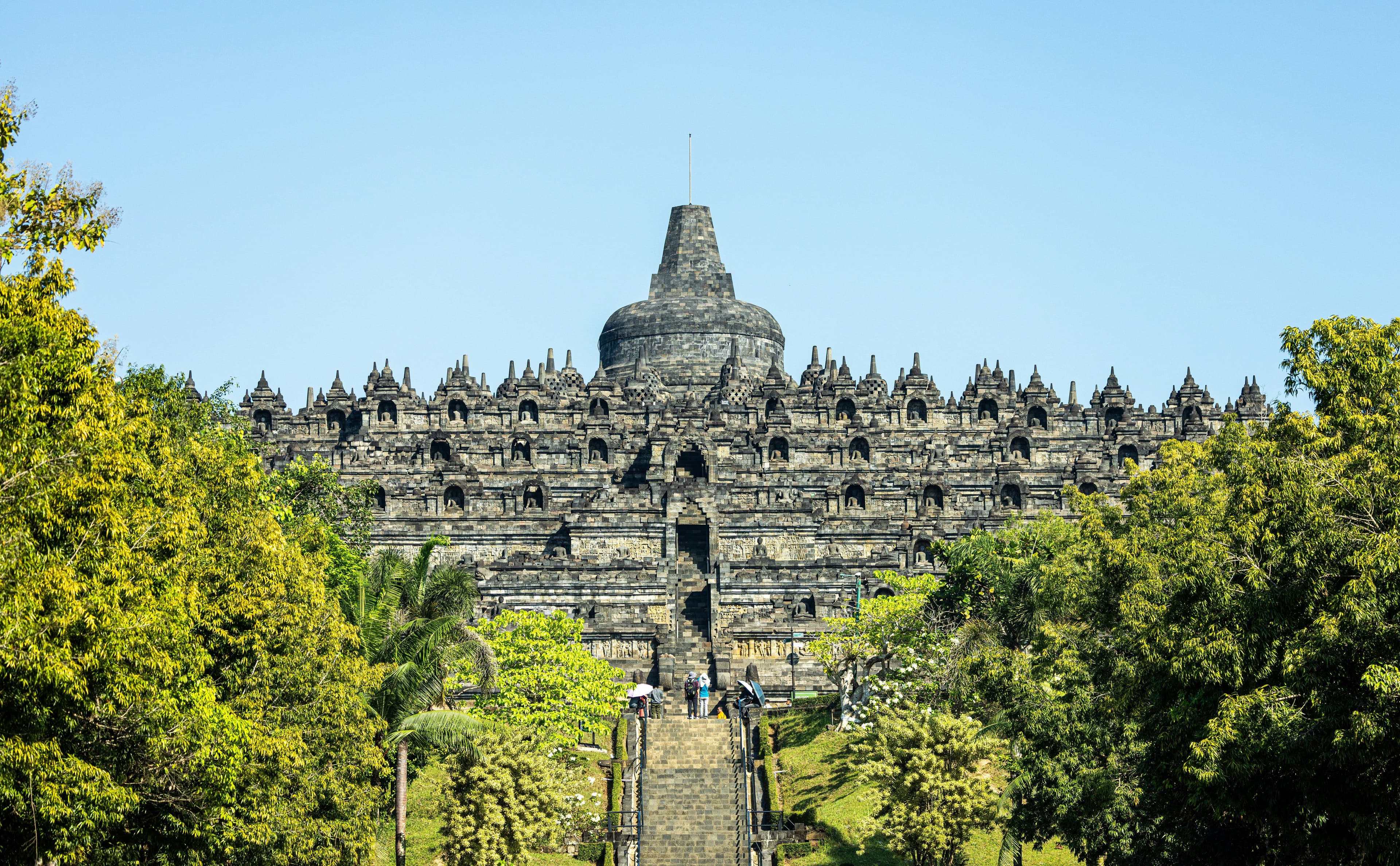 Temple at Borobudur with lush trees next to it
